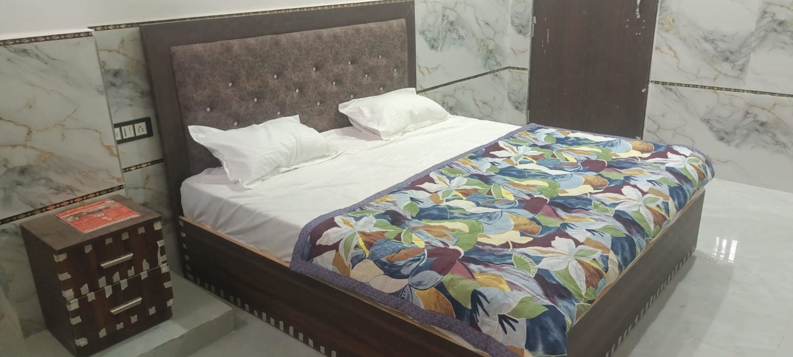 Double bed with fresh linen and patterned bedcover